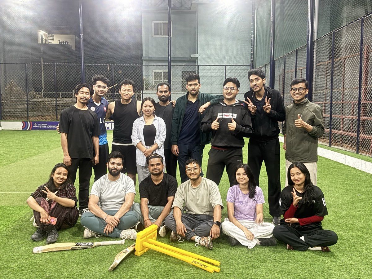 The team posing with bats and stumps